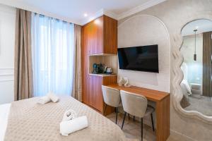 a bedroom with a bed and a desk with a television at Garbo Hôtel in Paris +41 photos