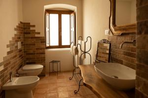un bagno con due wc, un lavandino e uno specchio di Palazzo Pirro Dimora Storica a Acciano