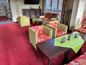 a living room with couches and a table and chairs at Hotel Phönix in Bad Füssing