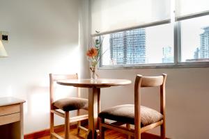 a table with two chairs and a vase with a flower at Salto Grande Hotel in Punta del Este