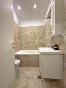 a bathroom with a sink and a tub and a toilet at Avangarde City bloc 7 in Roşu