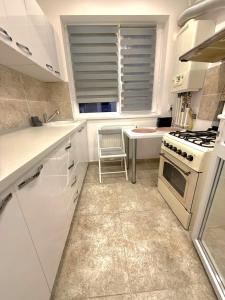a white kitchen with a stove and a window at Avangarde City bloc 7 in Roşu