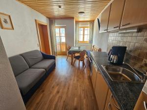 a kitchen and living room with a couch and a table at Haus Bergblick in Obertauern