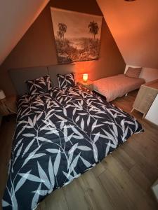 een slaapkamer met een zwart-wit dekbed op een bed bij Ti Eog Glas in Quimperlé +3 foto's