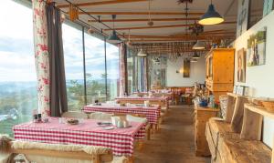 a restaurant with tables and chairs and large windows at Samenkönig Pschait Handels GmbH in Gamlitz