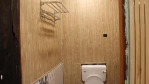 bagno con servizi igienici e parete in legno di Dipankar House a Tezpur