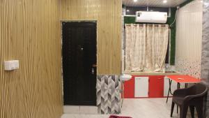 una stanza con una porta nera e un tavolo con sedie di Dipankar House a Tezpur