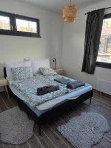 a bedroom with a bed with two rugs on it at Ohuta-Barn Vendégház in Parád