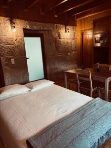 una camera da letto con un letto, un tavolo e delle sedie di Jardim da Celeste a Campia Altre 25 foto