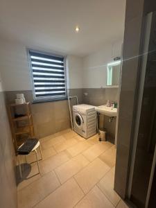 ein Badezimmer mit Waschmaschine und Waschbecken in der Unterkunft Trafford Sky Homes in Leipzig