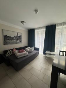 ein Wohnzimmer mit Sofa und blauen Vorhängen in der Unterkunft Trafford Sky Homes in Leipzig
