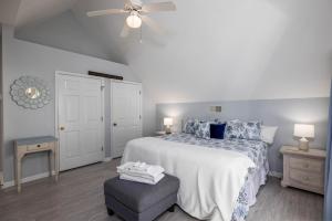 een witte slaapkamer met een bed en een plafondventilator bij 33 Davis Love in Fripp Island +40 foto's