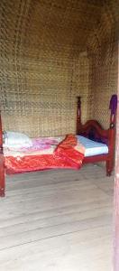 a small bed in a room with a wall at Wycliffˋs Eco Lodge in Kabale