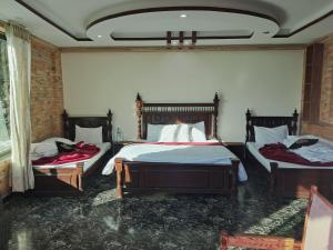a bedroom with two beds with red blankets on them at Nathia Gali Relax Inn Hotel in Naka