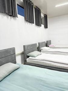 a room with three beds in a room at Karakol-Guest in Karakol