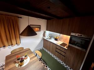 a small kitchen with a wooden table and a table and chairs at Wellness house Svjetlost in Jahorina