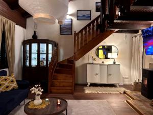 a living room with a staircase and a room with a couch at Wellness house Svjetlost in Jahorina