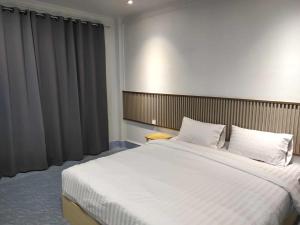 a bedroom with a large bed with white sheets at Betong Chill House in Ban Hua Phrong