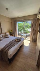 a bedroom with a large bed and a large window at DAKAR HOTEL in Mendoza +53 photos