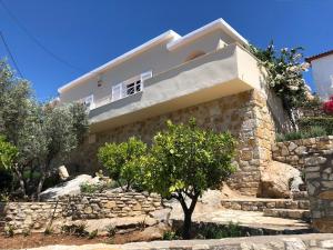 a stone house with a tree in front of it at Tranquility House Astros in Paralio Astros