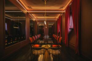 una sala da pranzo con un lungo tavolo e sedie di Torel Palace Lisbon a Lisbona Altre 175 foto