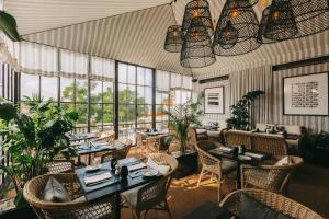 un ristorante con tavoli, sedie e finestre di Torel Palace Lisbon a Lisbona