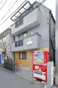 a red vending machine in front of a building at Tokyo My Home Private Room for 3 Guests near Shinjuku Shared Facilities in Tokyo