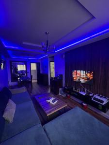 a living room with a couch and a fireplace with blue lights at Sweet appartement in Tangier