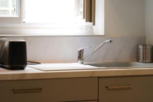 a kitchen counter with a sink and a window at Le Patio Spa in Chartres