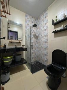 a bathroom with a black toilet and a sink at Sweet appartement in Tangier