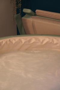 un letto chiuso con lenzuola bianche di Le Patio Spa a Chartres