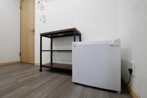 a room with a bed and a refrigerator next to a wall at Tokyo My Home Private Room for 3 Guests near Shinjuku Shared Facilities in Tokyo