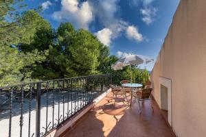 a balcony with a table and chairs and an umbrella at RAPIA Casa Beig 5 in Moratalla