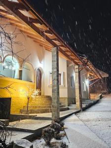 a house in the snow at night at Casa Hera in Călimăneşti