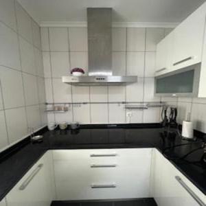 een keuken met een wit aanrechtblad en witte kasten bij Casa cidade e piscina in Coimbra +58 foto's