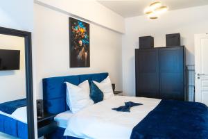 a bedroom with a blue and white bed and a mirror at Royal Blue Iasi in Iaşi