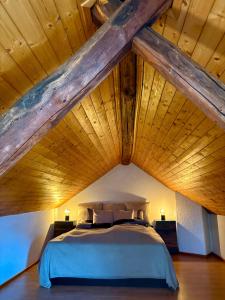 a bed in a room with a wooden ceiling at Residenza Valentino in Locarno