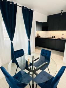 a living room with a glass table and blue chairs at Royal Blue Iasi in Iaşi +17 photos
