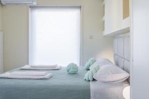 a bedroom with a bed with two pillows and a window at Glyfada Cove Apartments-Ostria in Athens +27 photos