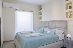 a bedroom with a bed with towels on it at Glyfada Cove Apartments-Ostria in Athens