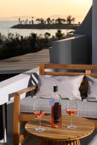 a bottle of wine and two glasses on a table at Glyfada Cove Apartments-Ostria in Athens