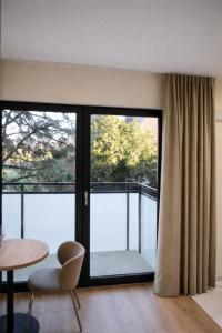 a room with a large window and a table and chairs at Apartments Rajska 77 in Wrocław