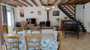 a dining room and living room with a table and chairs at Gite 3 du Bas Coudreau in Rosnay
