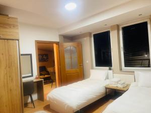 a bedroom with two beds and a desk and a table at Urban Boutique Apartments in Bitola
