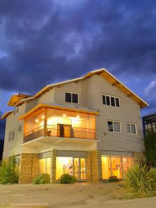a large white house with its lights on at Hostel 360 Patagonia in El Bolsón
