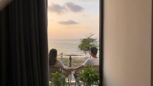 a couple sitting on a balcony looking out at the ocean at Lucky Wave Beach Resort in Colombo
