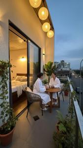 two people sitting at a table on a balcony at Lucky Wave Beach Resort in Colombo