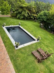 a swimming pool with a bench and a picnic table at GRACE COTTAGE Charming 2 Bed en-suite Cottage with Solar in Cape Town