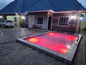 a swimming pool with red lights in front of a house at ES Apartments in Dodoma