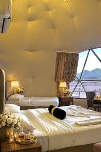 una camera d'albergo con due letti e una grande finestra di Katrina Luxury Camp a Wadi Rum